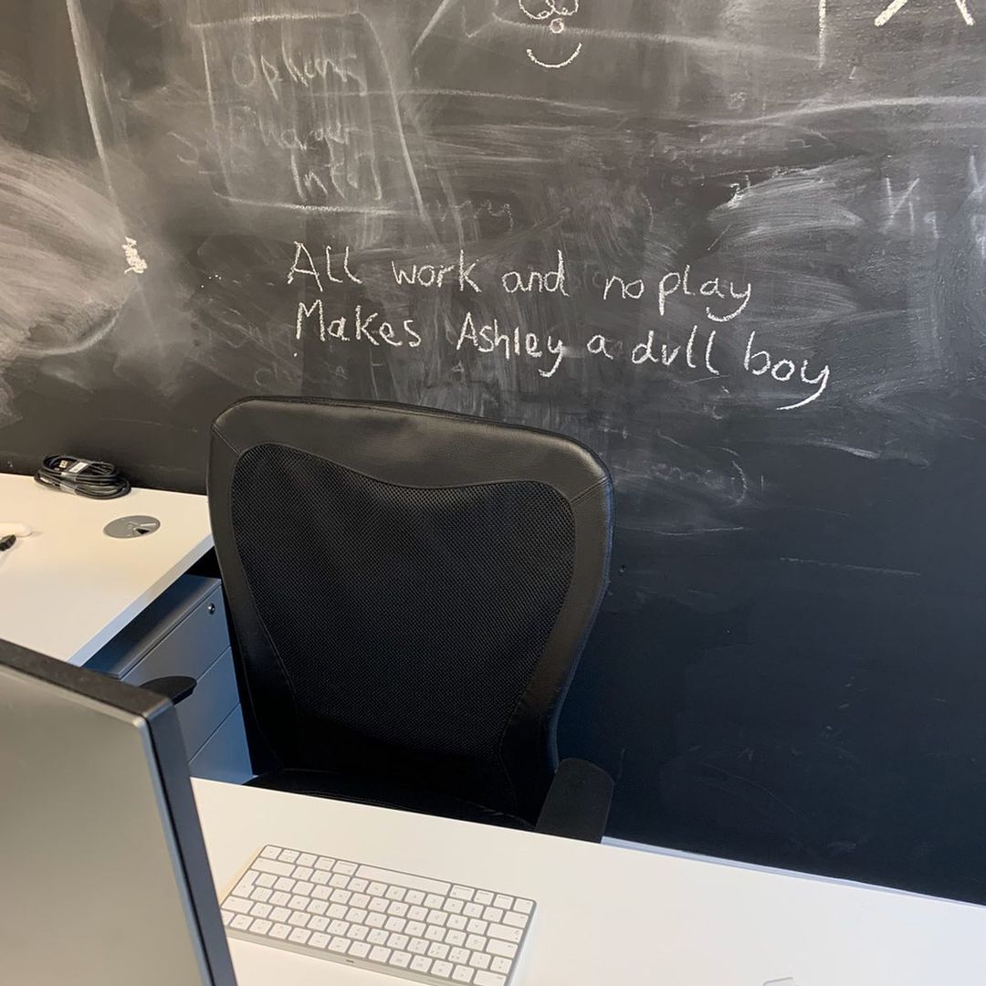 The words "all work and no play makes Ashley a dull boy" on a blackboard
