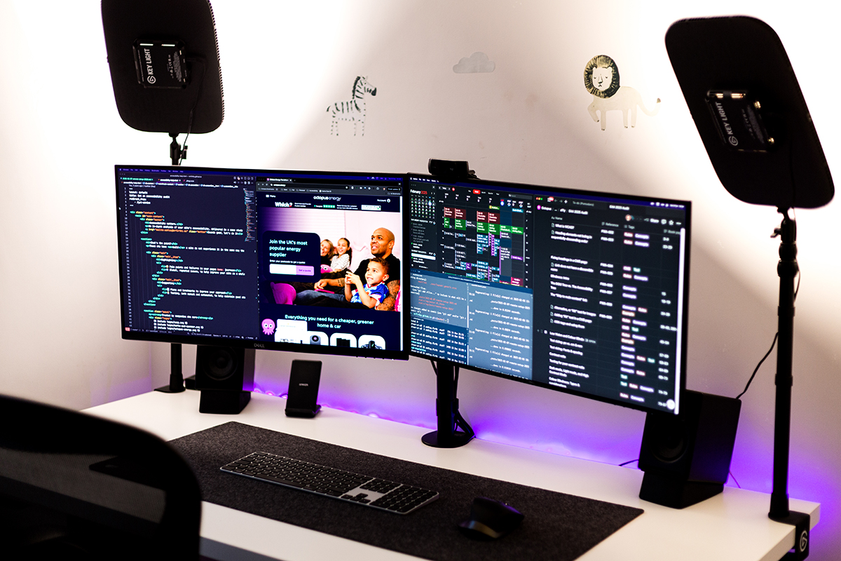 Side view of the desk. There's a felt desk mat with a keyboard and mouse, and a wireless charger